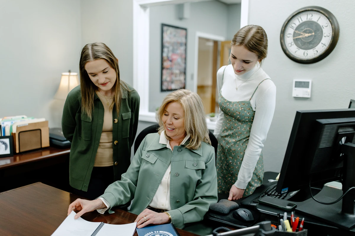 A staff member meeting with two students.